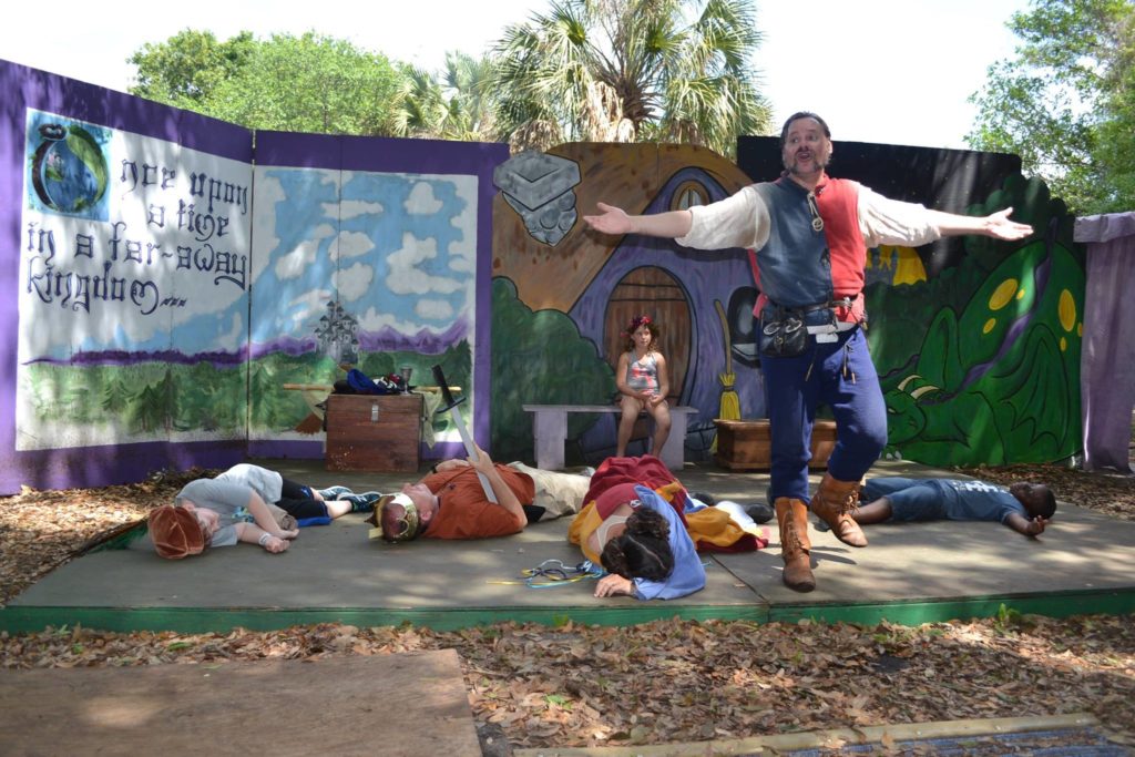 A faire stage show, a man dancing among fallen combatants