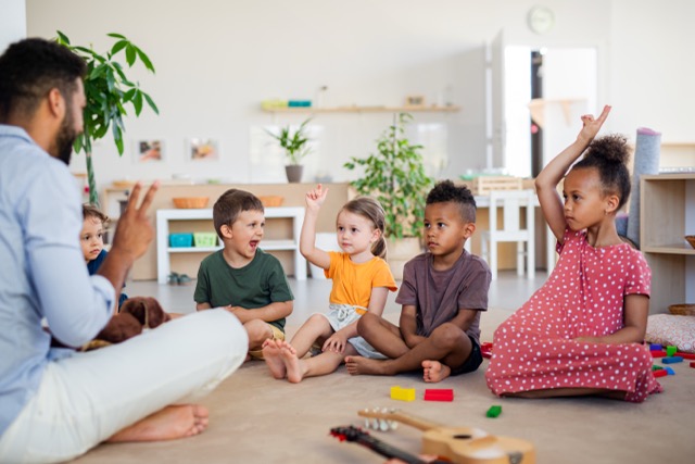 A group of small nursery school children sitting on the classroom floor