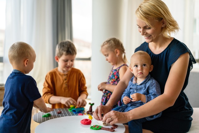 Child development: family activities in the kids room, a woman and children playing together