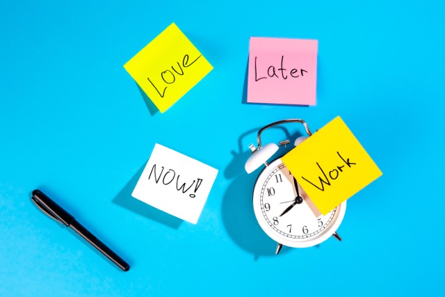 Sticky notes reading Love, Later, Work and NOW beside an alarm clock