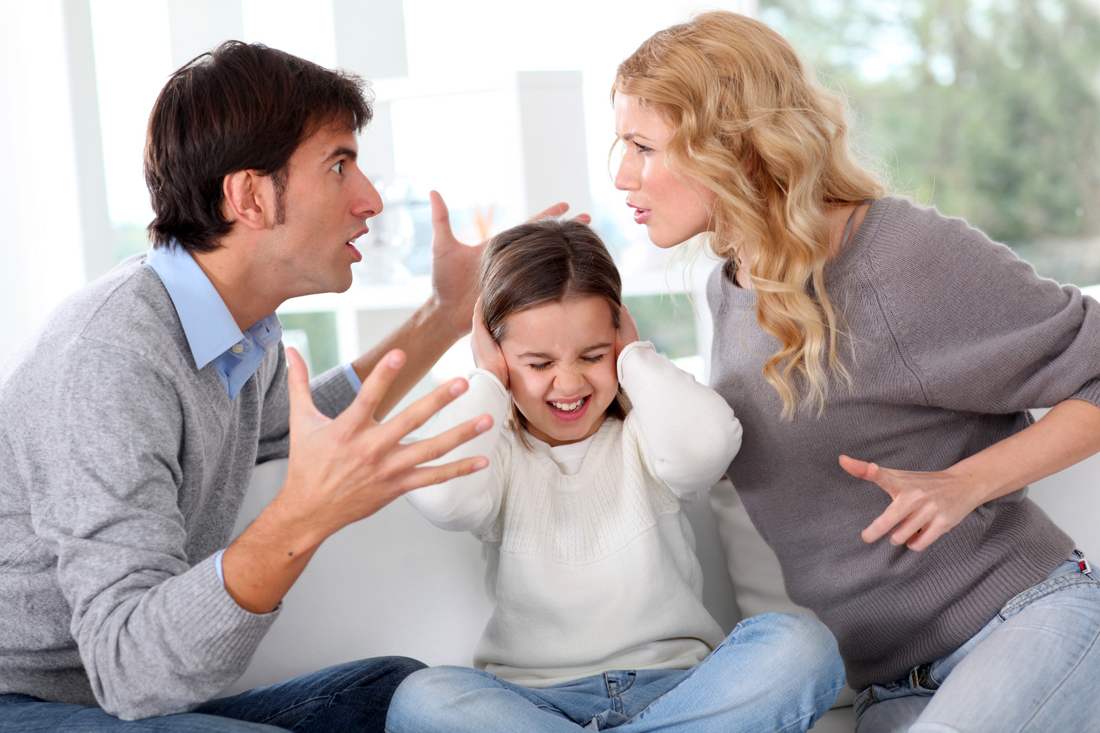 Two adults arguing in front of their daughter