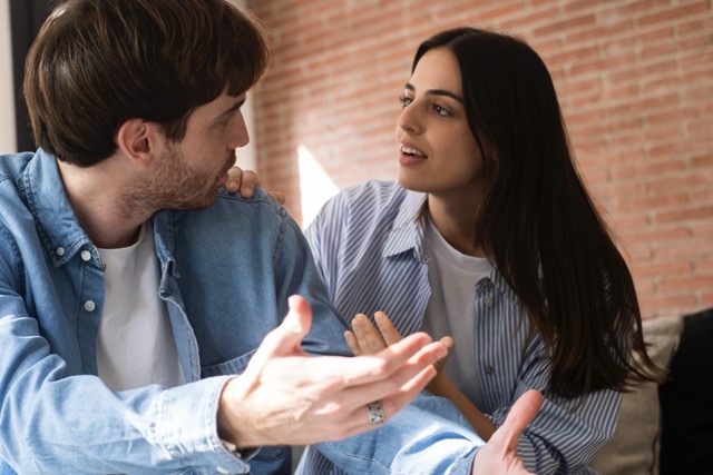 An unhappy young couple sitting apart, avoiding talking to each other