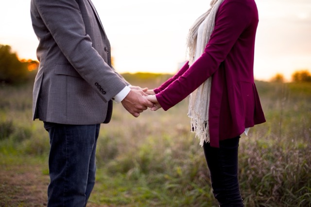 A close up of a couple holding hands