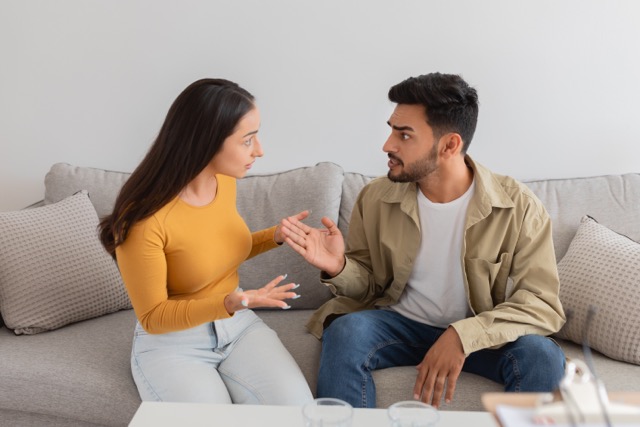A couple having a difficult conversation on the sofa