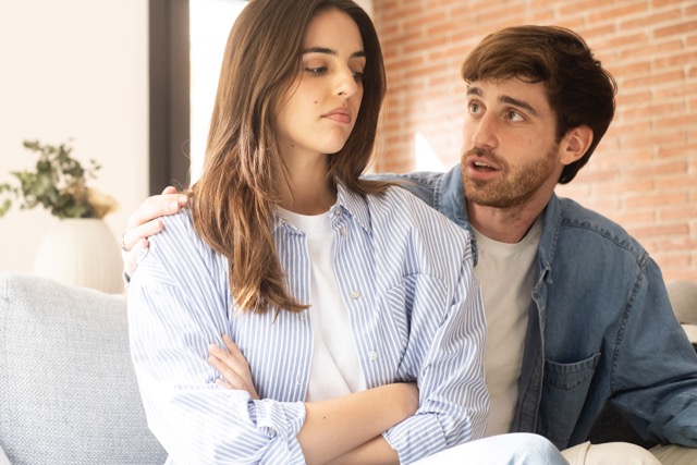 An engaged couple sitting with relationship problems between them