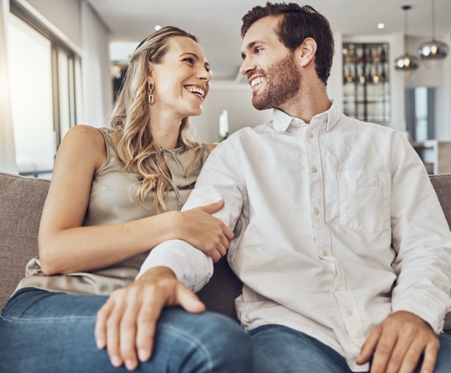 A couple relaxing and laughing together on the sofa