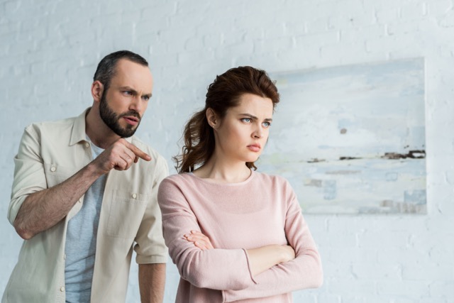A man pointing a finger at an upset woman