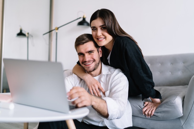 A couple working together on a laptop in the living room