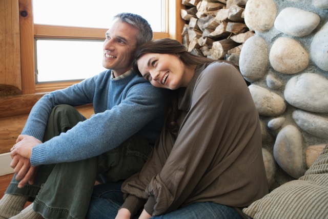 The foundations of a happy marriage: a mid adult married couple sitting in a log cabin together
