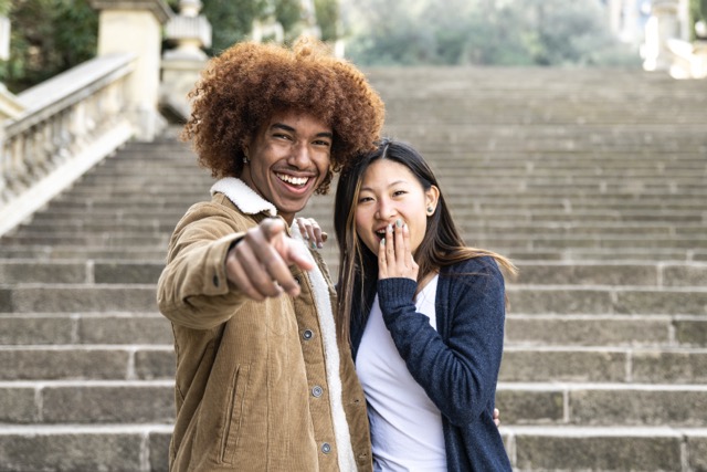 A multiracial couple laughing together in the park
