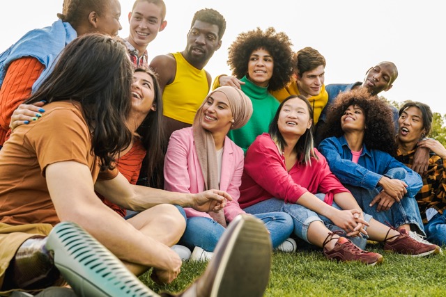A group of friends laughing outdoors in summer