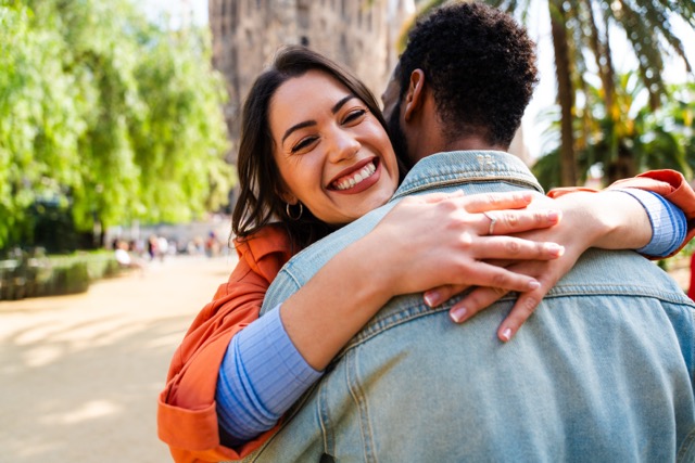 A multiracial married couple hugging each other