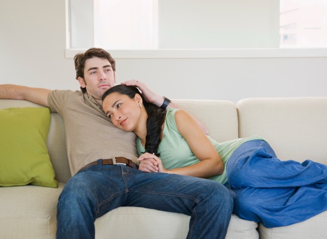 A couple sitting together on the couch