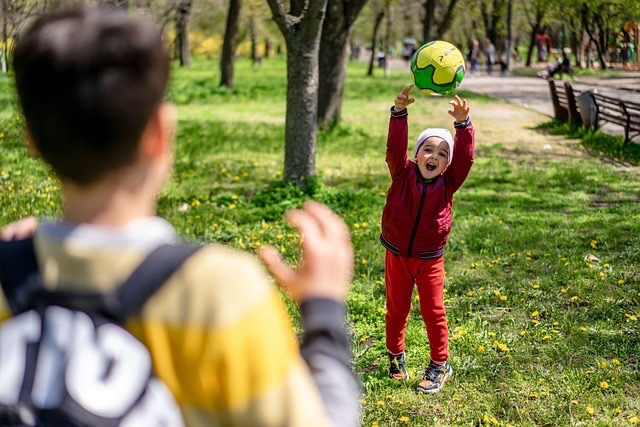 Two children playing football together in the park