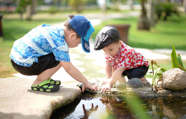 Two young children playing together in the water