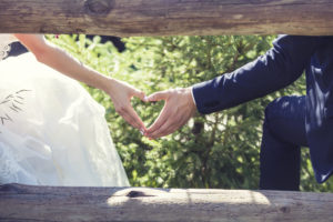 A married couple making a heart shape with their hands