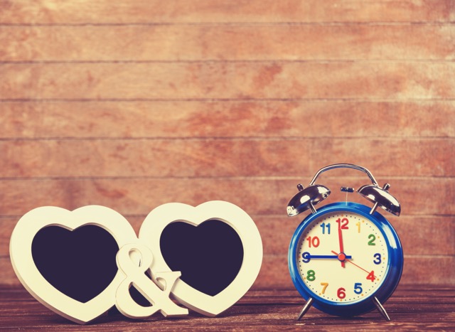 A heart shaped decoration beside a colorful alarm clock