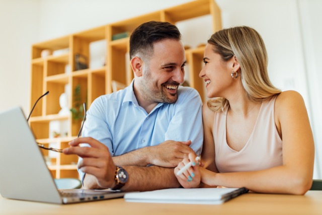 A couple at the home office desk, talking through their plans
