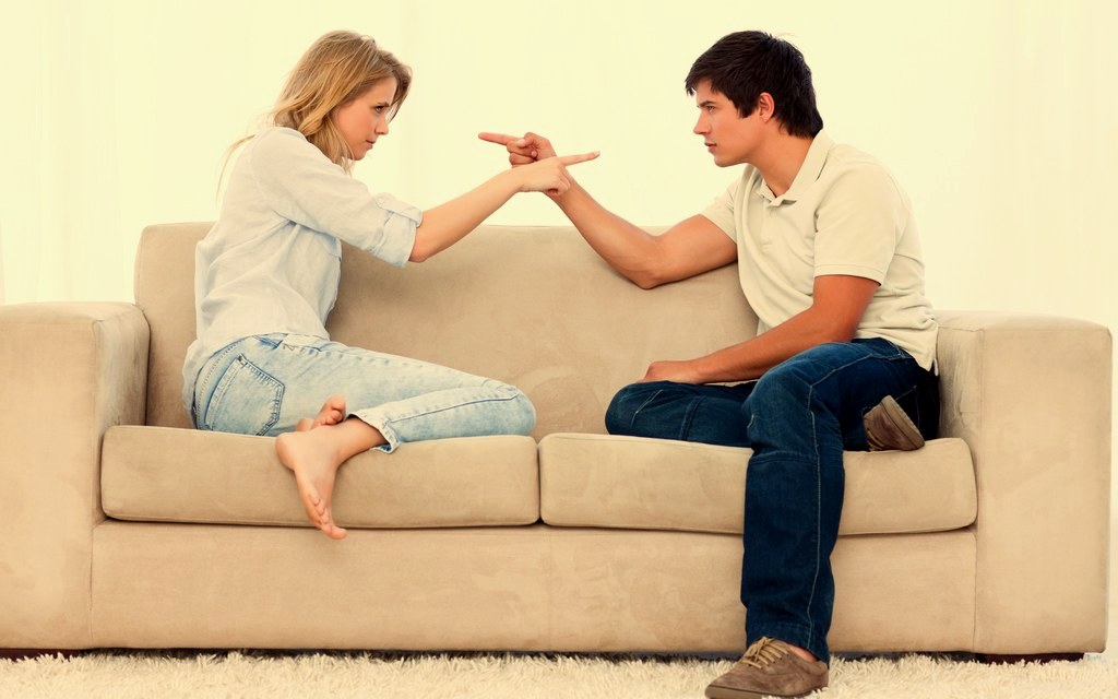 A couple sitting close together on a couch at home