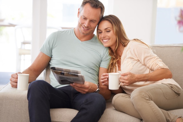 A couple sitting together on the sofa with coffee