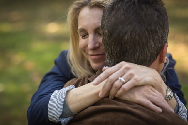 A close up of a mature couple hugging in the garden