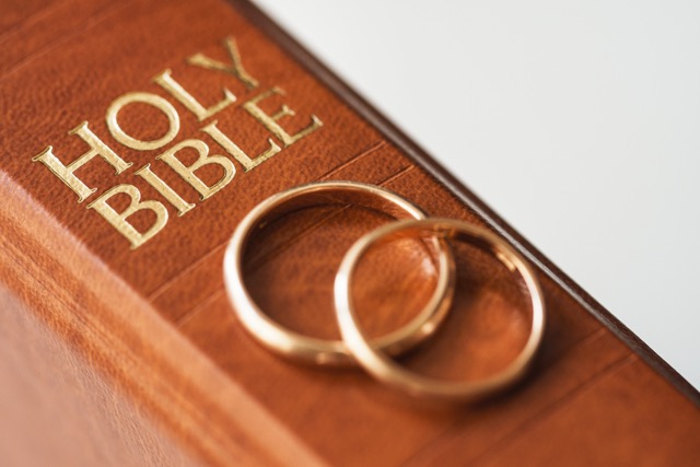 Two golden wedding rings resting on a bible