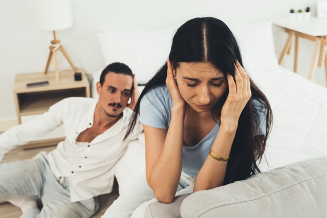 An upset and unhappy young couple having a quarrel at home