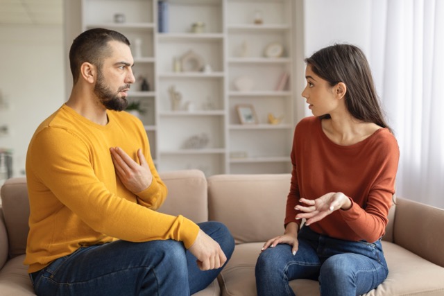 A couple having an emotional conversation on the couch at home