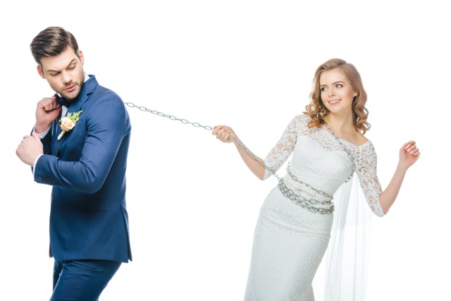 A groom holding his bride while chained at the ankle