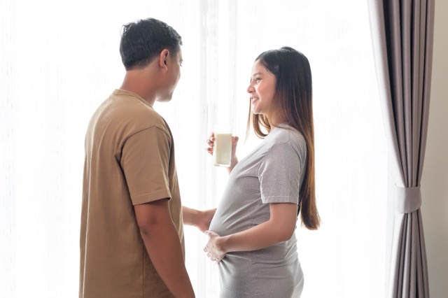 A pregnant woman at home with her husband looking after her