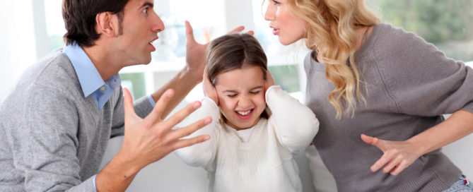 Two adults arguing in front of their daughter