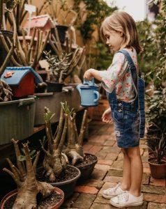 Young girl watering plants
