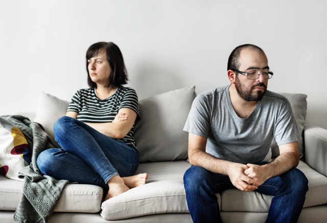 Unhappy couple arguing on the sofa