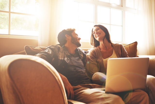 Love and laughter. Cropped shot of a young couple relaxing on the sofa at home