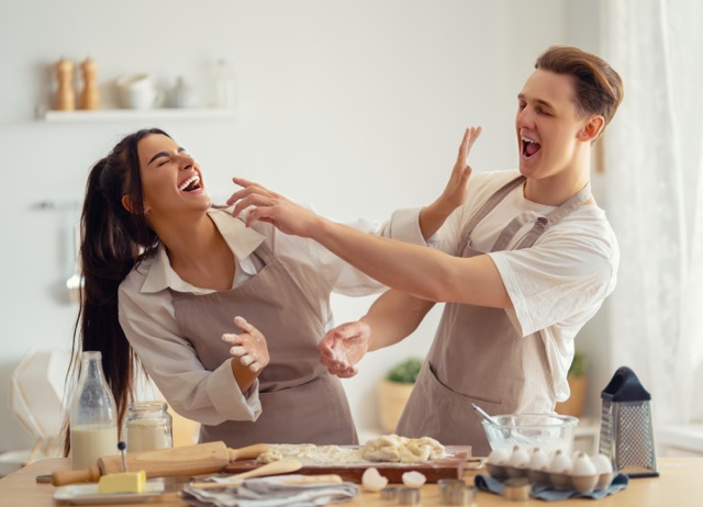 Happy loving couple is preparing the pastry in the kitchen.