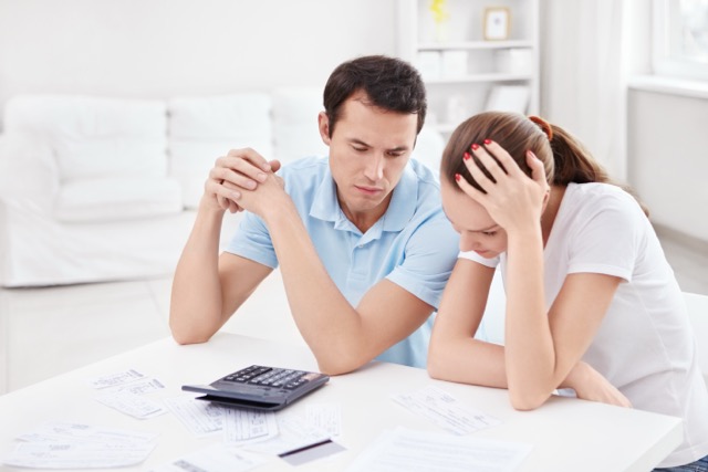 Financial Stress: Young couple for the calculations at home.