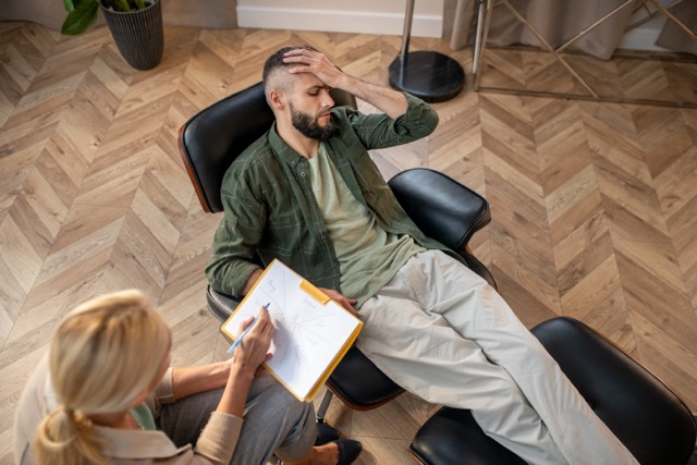 Trauma Therapist In Miami: Sharing personal problems. Man wearing checked shirt sharing personal problems with psychologist