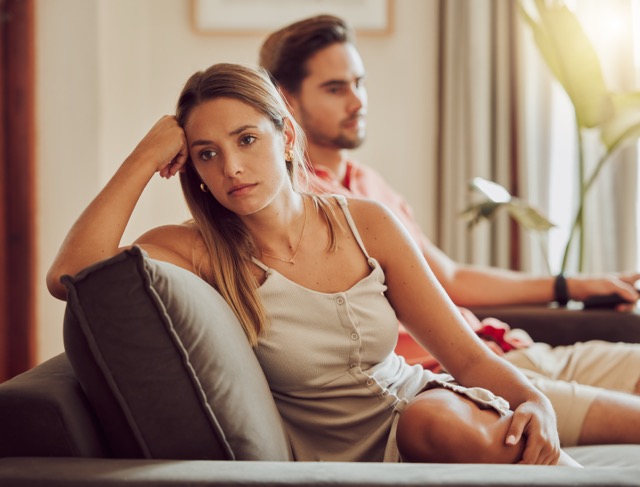 Signs of Infidelity In A Relationship: Unhappy, sad and annoyed couple after a fight and are angry at each other while sitting on a couch .