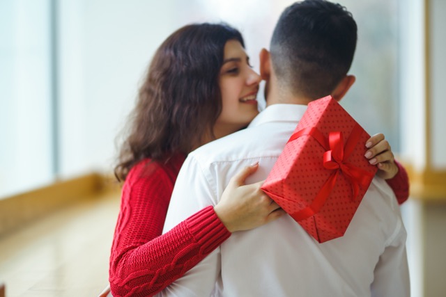 A young man gives his beloved a present and closes her eyes with a hand. Promise Day.