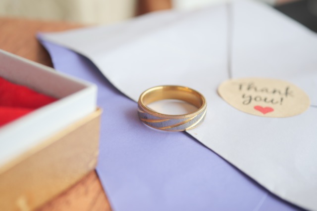 A beautiful personalized promise ring rests on an elegant envelope with a heartfelt thank-you note.