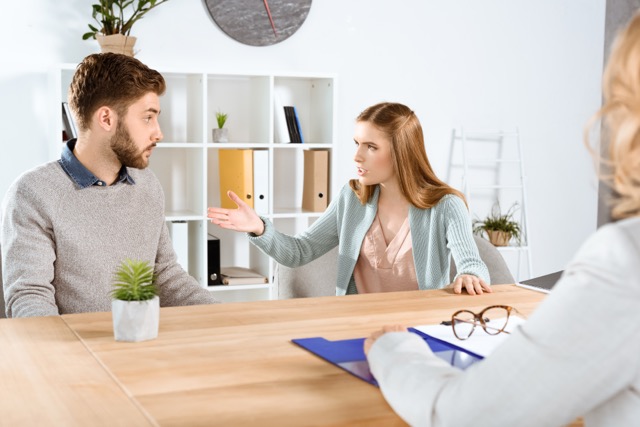 cropped shot of psychologist and emotional young couple quarreling during therapy