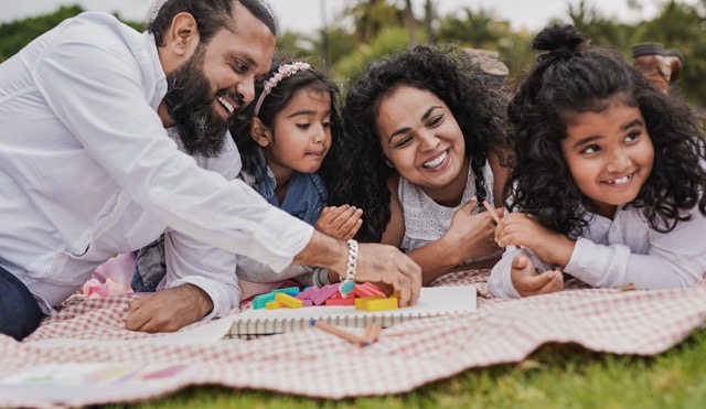 Happy indian family enjoy playful time together at city park