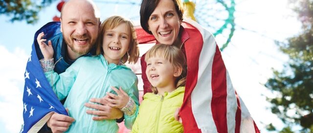 American family looking at camera in park of entertainment