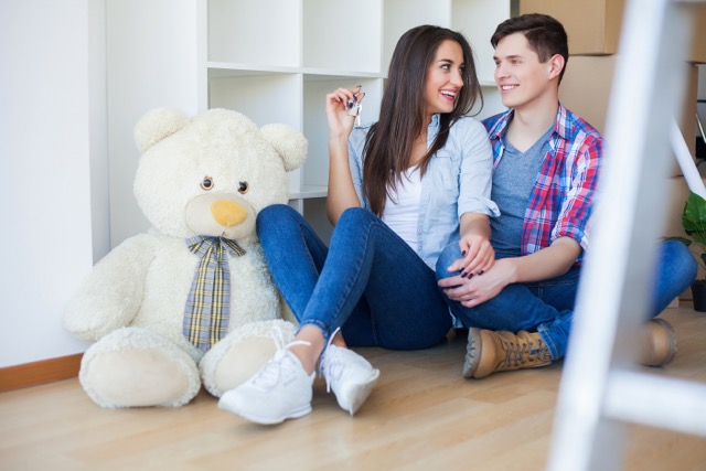 Moving to a new apartment. Happy family couple and cardboard box