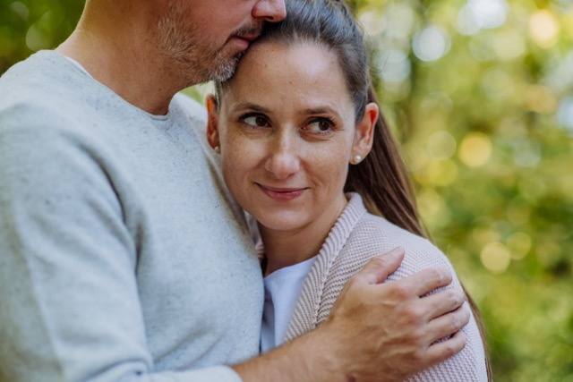 Portrait of happy marriage couple in love,standing in a forest.