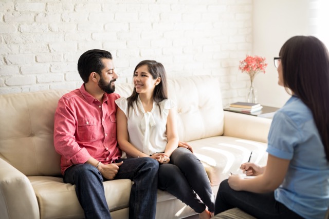 marriage Counselor and happy marriage couple Hispanic couple after effective marital therapy.