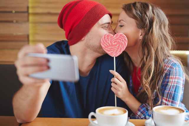 Amorous guy and girl making selfie of their kiss