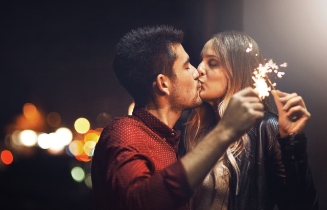 Shot of a happy young couple celebrating with sparklers outside at night.