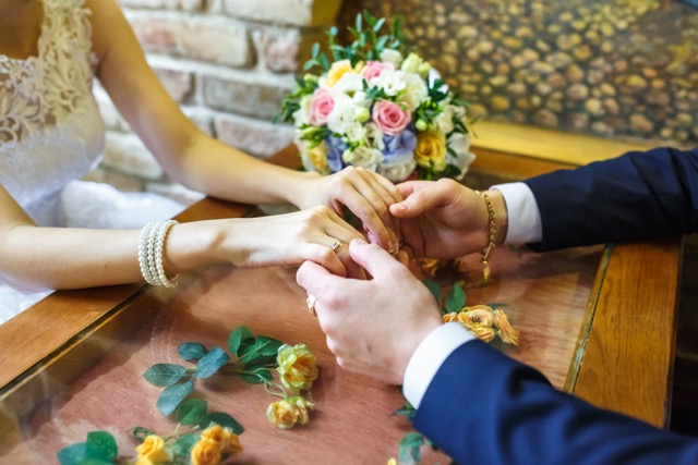 The groom holds the hands of his bride on their wedding day