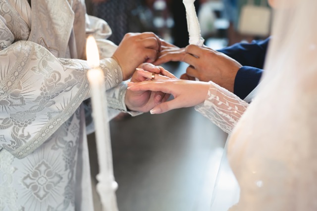 The priest consecrates the wedding rings on the fingers of the bride and groom. Wedding tradition and ritual. hands of a young couple in the church.